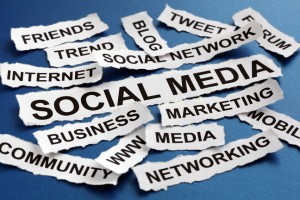 Social media concept torn newspaper headlines reading marketing, networking, community, internet etc